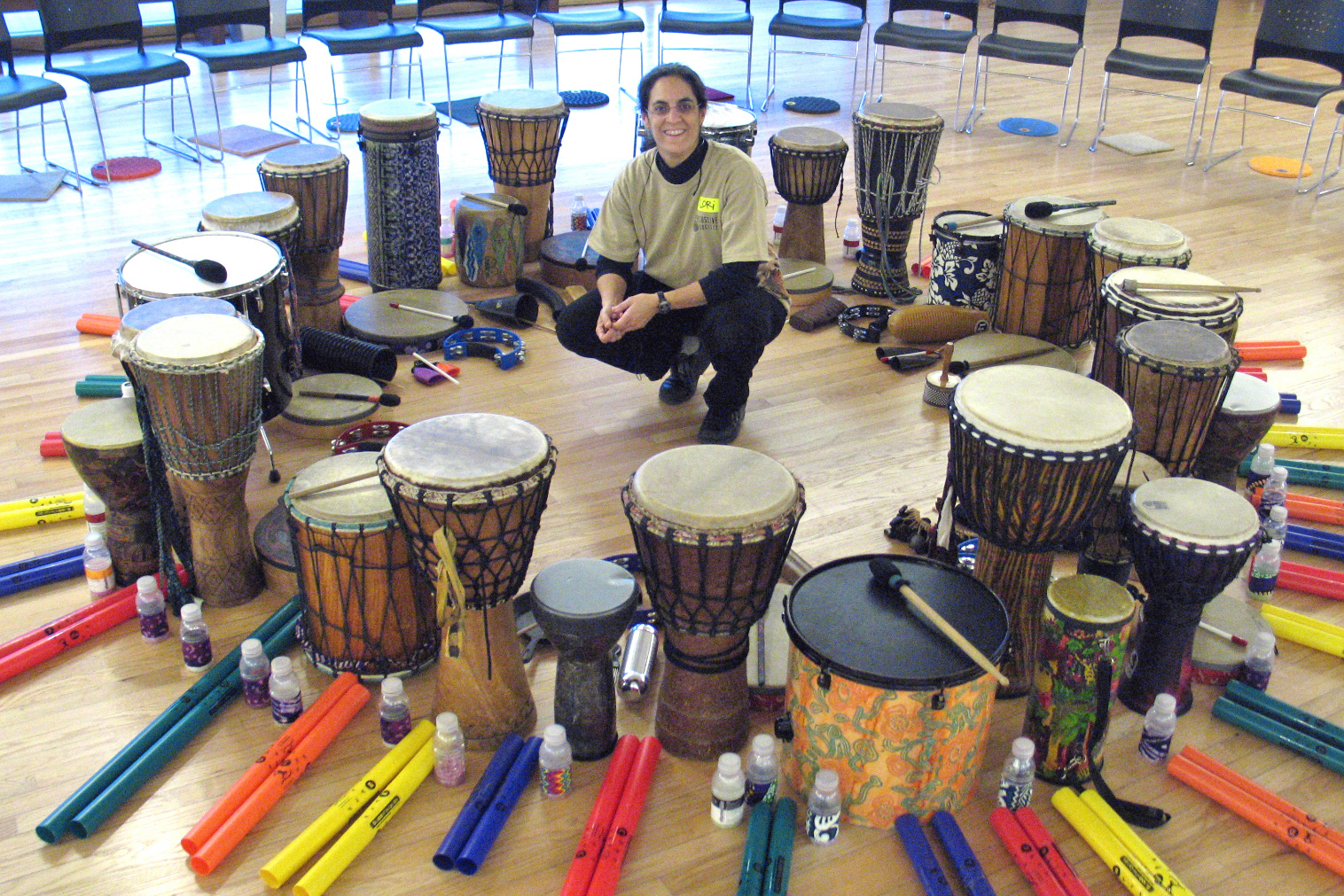 a woman encircled by drums of different types and sizes